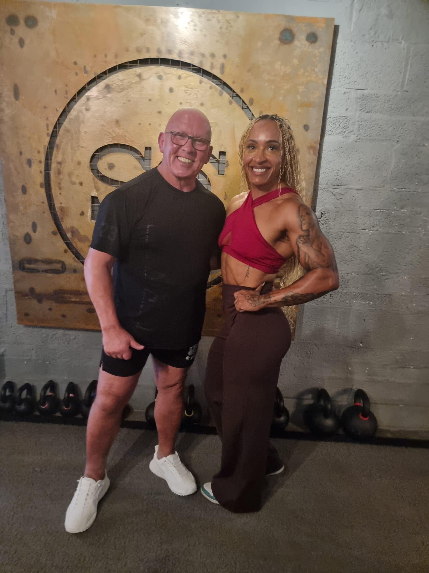 Derek Lyons recovery specialist with competitive female bodybuilder at gym